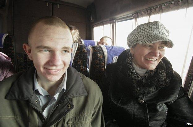 A freed Ukrainian soldier sits beside his mother on a coach in Luhansk, 26 December