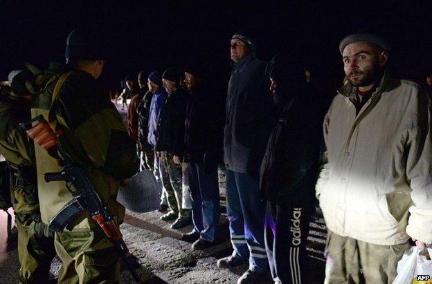 Rebel gunmen face Ukrainian prisoners prior to their release near Donetsk, 26 December