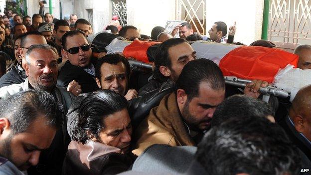 Mourners carry the coffin of Shaima al-Sabbagh, an Egyptian protester who was killed in clashes with the police, during her funeral on January 25, 2015 in Egypt"s second city Alexandria