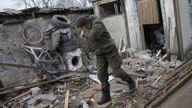 A man examines debris at a destroyed garage after shelling in Donetsk, Ukraine - 11 February 2015