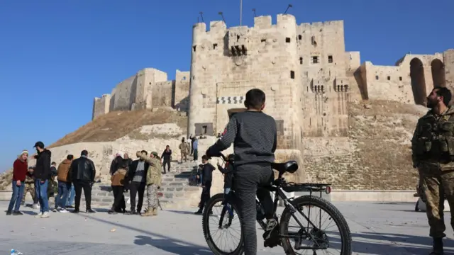 A number of people gathered in front of the citadel of Aleppo