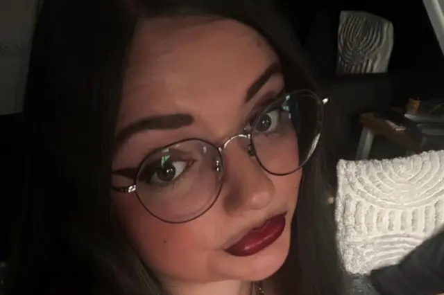 Katie, a woman wearing glasses