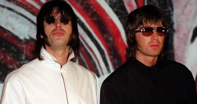 Liam Gallagher, in a white jacket, stood next to Noel Gallagher, in black