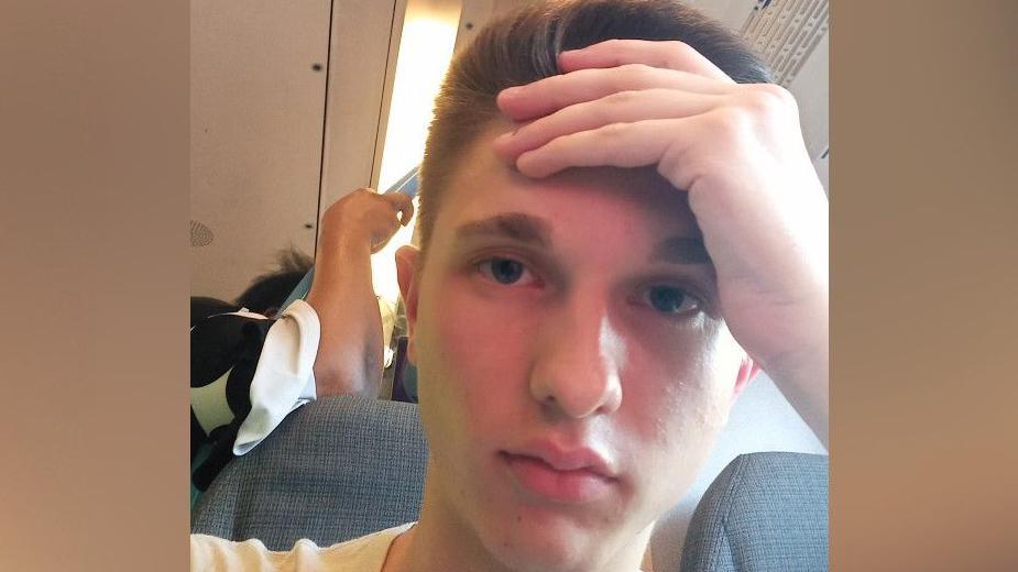 Sam Williams sat on a train with his hand pressed against his forehead looking disappointed