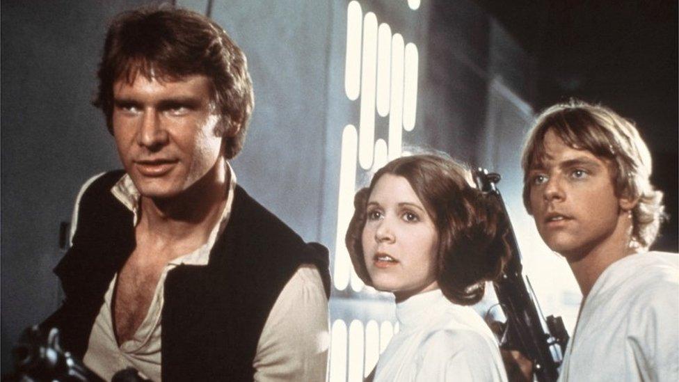 Harrison Ford, Carrie Fisher, and Mark Hamill are shown in a scene from Star Wars