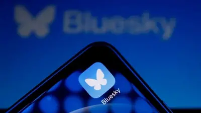 Приложение Bluesky на телефоне. Логотип в виде белой бабочки на голубом фоне напоминает птицу, которая была логотипом твиттера до того, как тот стал X.