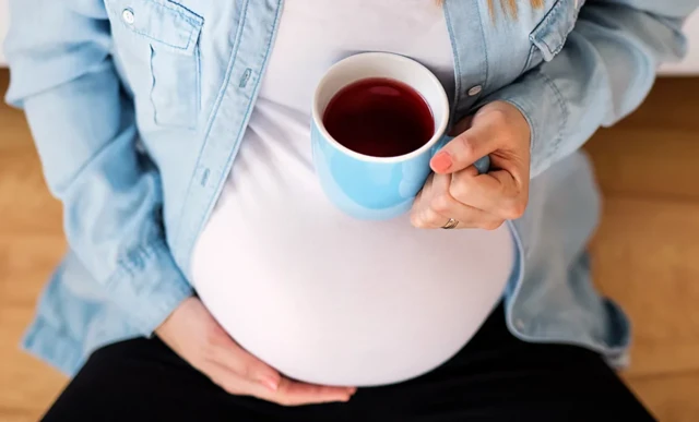 Une femme enceinte avec une tasse de café