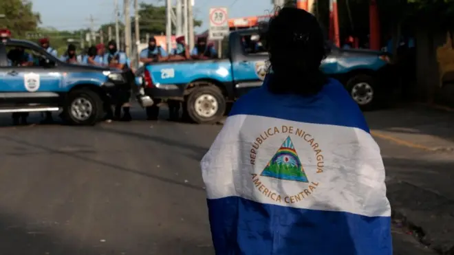 Un estudiante frente al bloqueo de la policía en el ingreso a la iglesia Divina Misericordia de Managua.