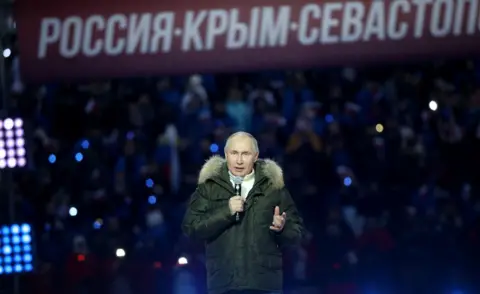 Getty Images Russian President Vladimir Putin speaks during a concert marking the 7th anniversary of Crimea annexation, on March 18, 2021 in Moscow, Russia