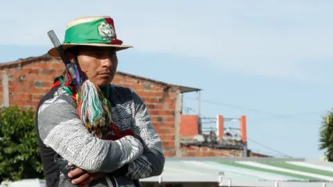 EPA An indigenous man prepares before leaving in a caravan from Fusagasuga to Bogota, Colombia, 18 October 2020.