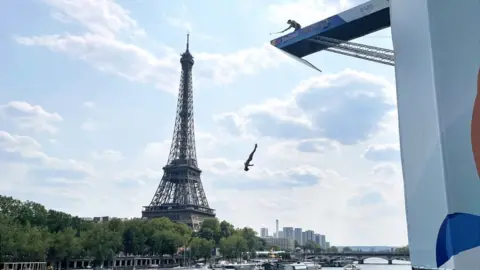 BBC A diver jumps from a platform at the River Seine in Paris, France