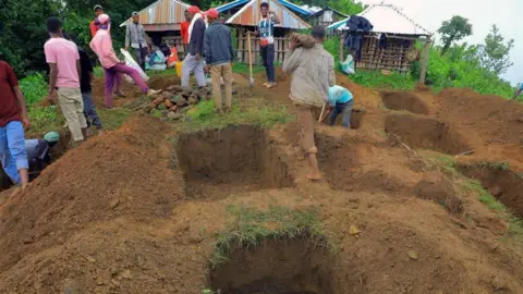 EPA Relatives of the victims of a landslide dig graves near the accident site in the Kencho Sacha Gozdi district, Gofa Zone, southern Ethiopia, 24 July 2024