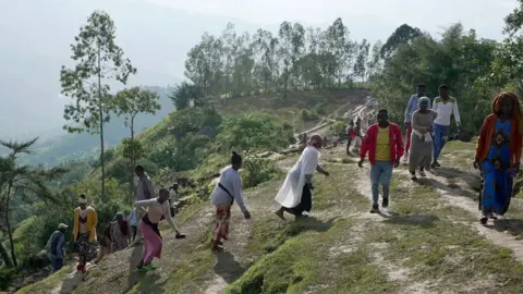 BBC/Amensisa Ifa People walking up a steep path in Gofa at the scene of two landslides