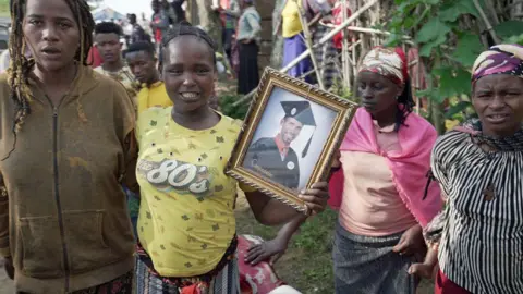 BBC/Amensisa Ifa People holding up a photo of one of those who died in a landslide in Gofa, Ethiopia - 24 July 2024