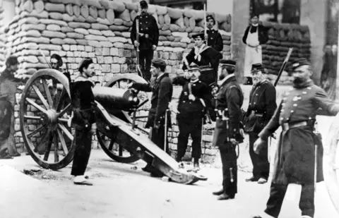 Hulton Archive/Getty Soldiers and a gun at the barricade at the Rue Castiglione during the conflict between the authorities and the radicals declaring the Paris Commune