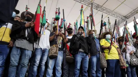 EPA Indigenous protesters raise their batons during a symbolic "impeachment" of President Iván Duque in Bogotá. Photo: 19 October 2020