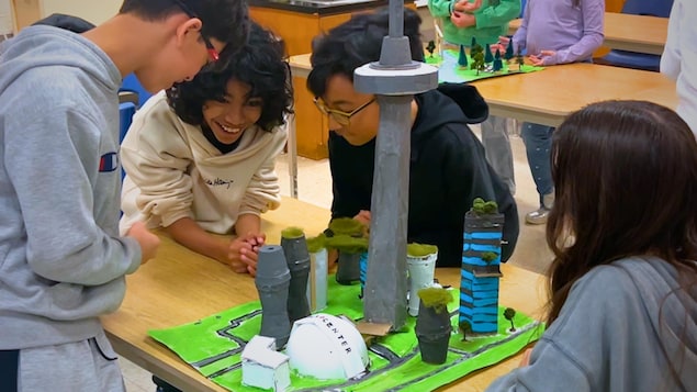 4 enfants sont autour d'une maquette représentant la Tour CN.