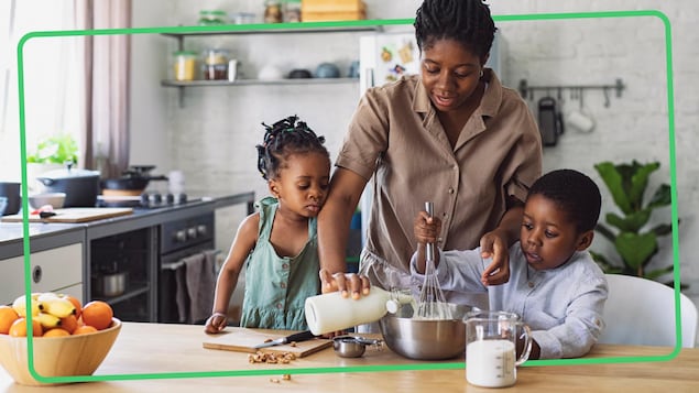 Une maman cuisine avec sa fille et son fils. 