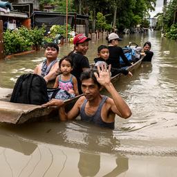 Philippinen: Menschen bringen sich auf in einem Boot auf überfluteten Straßen in Sicherheit.