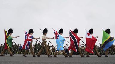 Wächter tragen während einer Probe für die Krönung von König Charles die Fahnen der Commonwealth-Staaten.