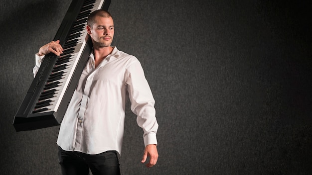 Foto grátis artista de camisa branca segurando teclado, cópia espaço