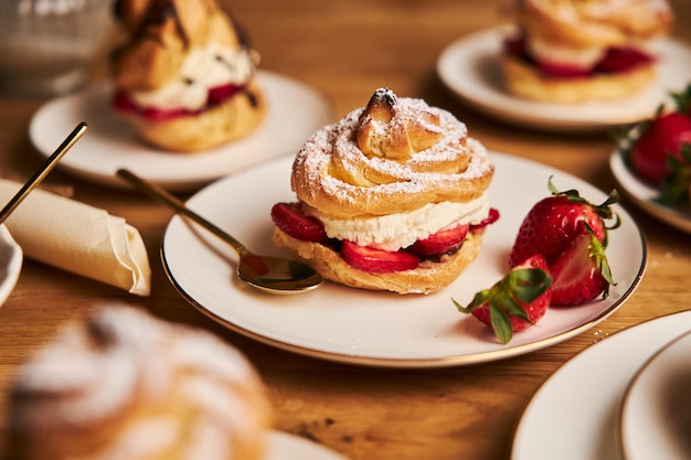 Foto grátis closeup tiro de uma deliciosa folha de creme com morangos em uma mesa de madeira