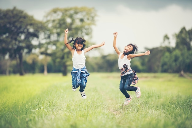 Foto grátis duas meninas felizes pulem no parque natural