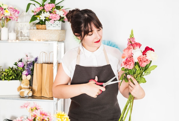 Foto grátis feminino florista cortando galhos de flores com uma tesoura