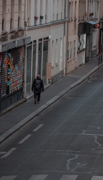 Foto grátis homem de casaco preto andando na calçada