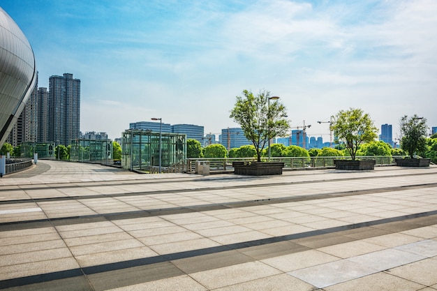 Foto grátis longo caminho vazio na praça da cidade moderna com horizonte.