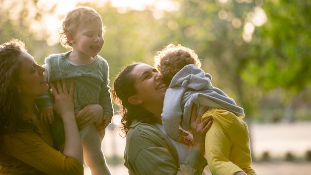 Foto grátis mães lgbt sorridentes ao ar livre no parque com seus filhos