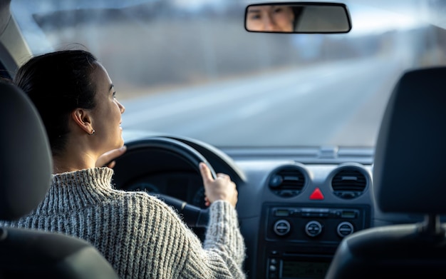 Foto grátis mulher jovem feliz dirige um carro dentro da vista