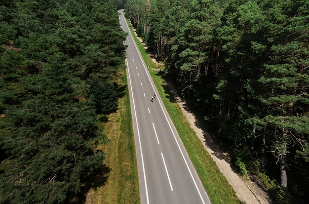 Foto grátis mulheres ciclistas profissionais de tiro no escuro na estrada