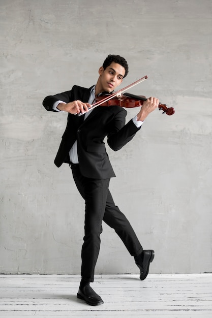 Foto grátis músico masculino dançando e tocando violino