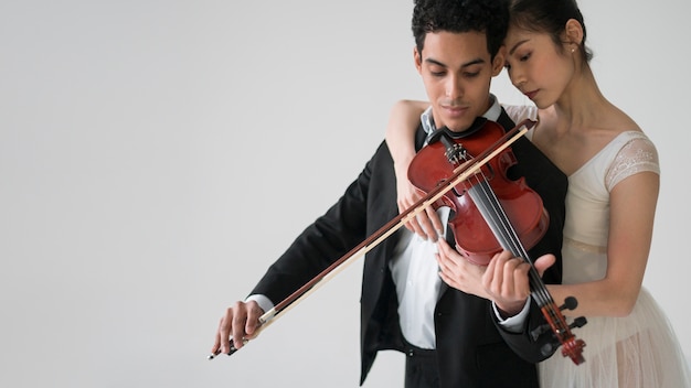 Foto grátis músico tocando violino com bailarina e copie o espaço