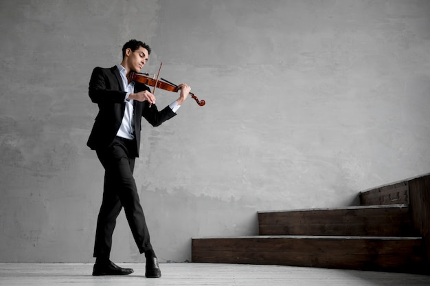 Foto grátis vista lateral do músico masculino tocando violino