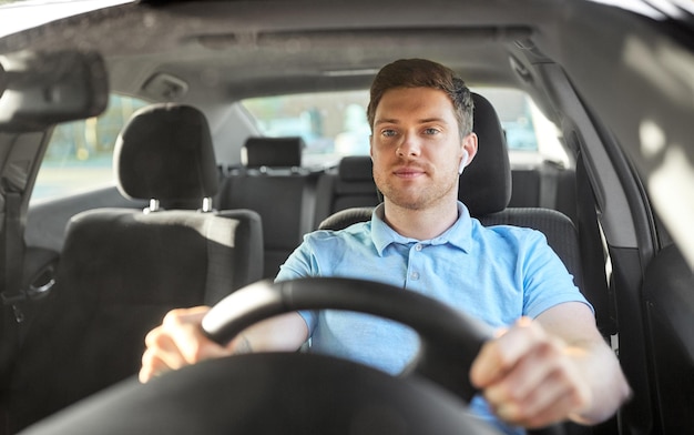 Foto homem ou motorista com fones de ouvido sem fios a conduzir um carro