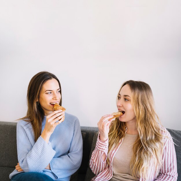 Free Photo | Women eating pastry on sofa