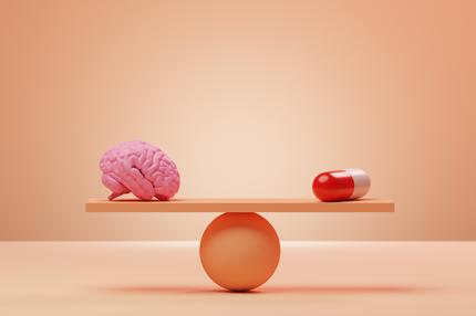 Vorasidenib: Conceptual image of an orange seesaw with a pink brain and an oversized pill balancing on it, could illustrate ideas around ssri, anti-depressants, headache pills and other medication for mental and brain health