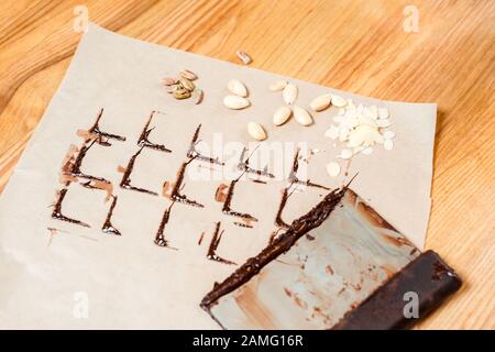 chocolate stains on baking paper near cake scraper and nuts Stock Photo