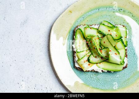 Cucumber and cream cheese toast on a plate. Healthy vegetarian diet concept. Stock Photo