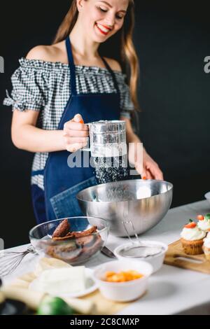 Woman Bakery Chef sifts flour, preparing the dough at studio Stock Photo