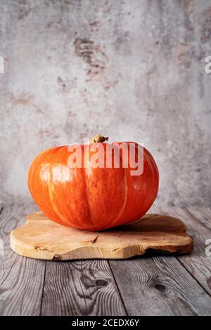 Single orange pumpkin on rustic wooden tray. Autumn, harvest, Halloween, Thanksgiving concept Stock Photo