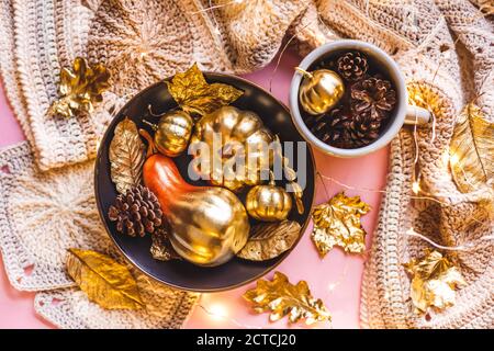 Autumn Frame with Shiny golden Decorative Pumpkins and leaves in bowl on a pnk bacround. Flat lay, top view trendy holiday concept. Stock Photo