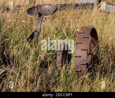 Wrought iron wheel on a vintage sickle bar hay mower on a ranch in Idaho, USA.  Now part of a private museum. Stock Photo