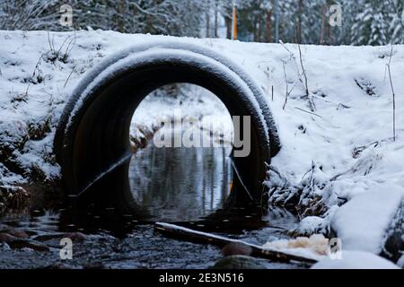 small road tunnel in winter where a stream can flow through Stock Photo