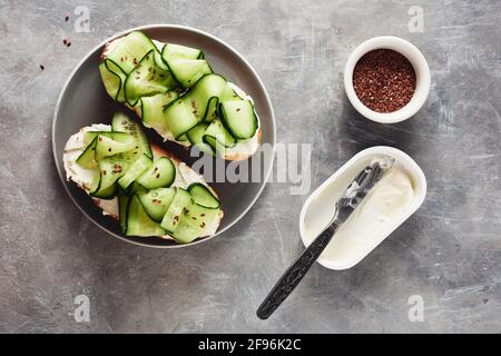 Sandwiches with cream cheese and cucumber on a gray table. Stock Photo