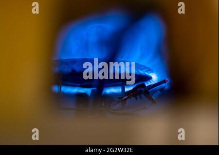 Pilot light auto igniter inside a hot water heater with flames Stock Photo