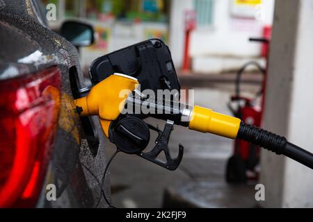 Pumping gasoline fuel in car at gas station. Stock Photo