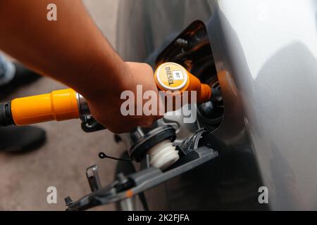 Hand Man Refill and filling Oil Gas Fuel at station. Pumping gasoline fuel in car at gas station. Stock Photo